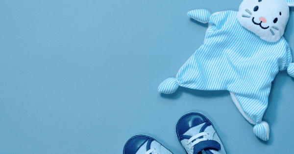Soft baby clothes and plush toys on a blue background, perfect for newborns and infants.