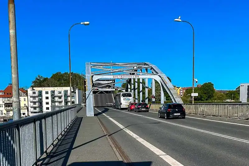 Udsigt over en bro med trafik, beliggende under en klar blå himmel med få skyer.