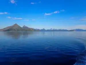 Blåt hav og blå himmel flotte bjerge i baggrunden