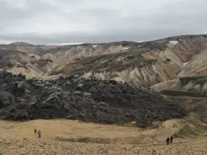 Vandring i farverigt landskab ved Laugavegur i Island – dramatisk natur med klipper, bakker og overskyet himmel