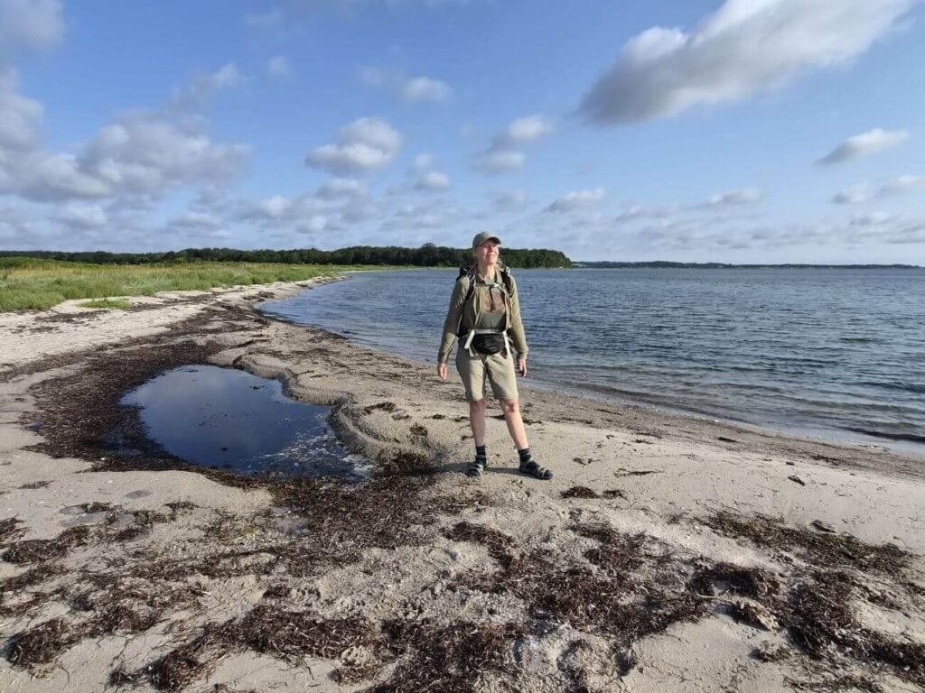En glad kvinde som står på en strand