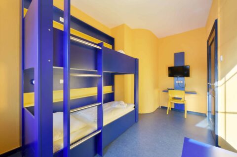 Comfort-Zimmer mit einem Etagenbett für zwei Personen, Schreibtisch, Stuhl und TV.