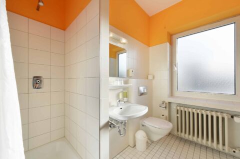 Comfort Badezimmer mit eigenem Waschbecken, Toilette, eigener Dusche und Fenster.