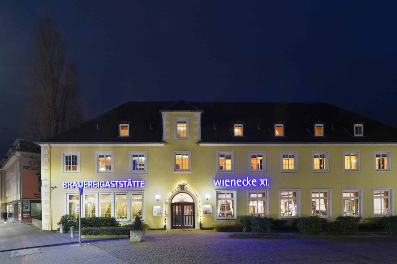 Gebäude der Brauereigastätte Wienecke XI. mit Beleuchtung bei Nacht.