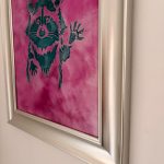 Pink background with black dog silhouette art in silver frame.