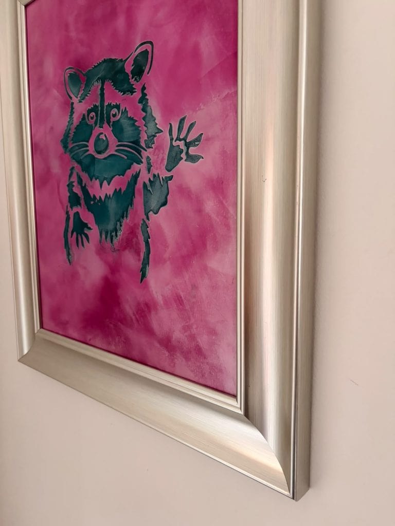 Pink background with black dog silhouette art in silver frame.