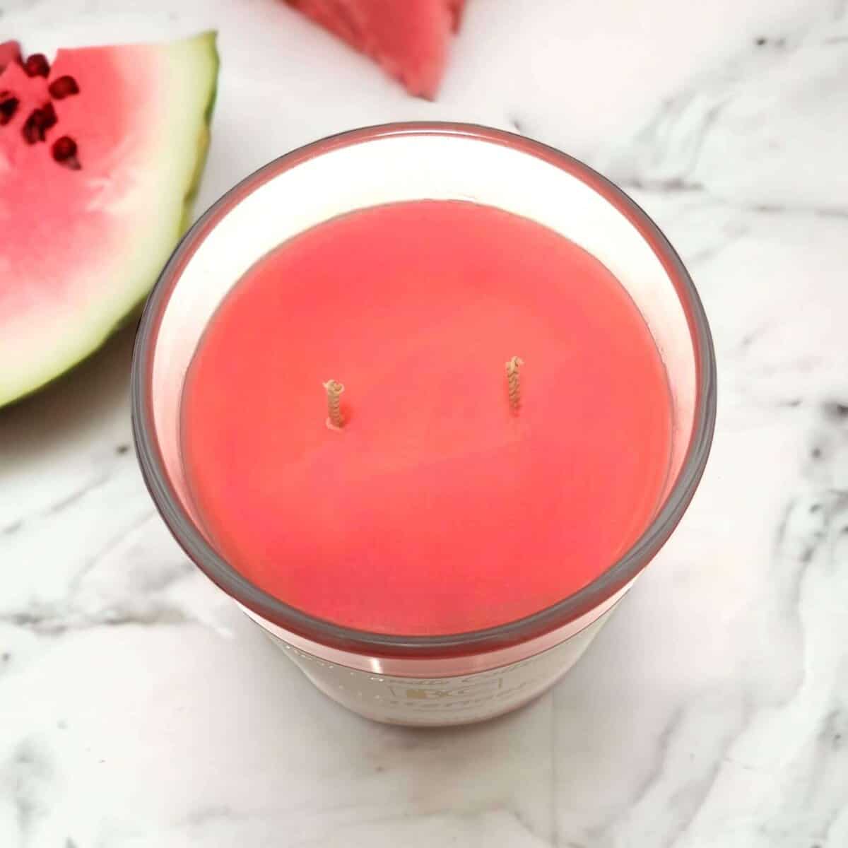 Bright watermelon soy wax candle with dual wicks, perfect for summer home decor.