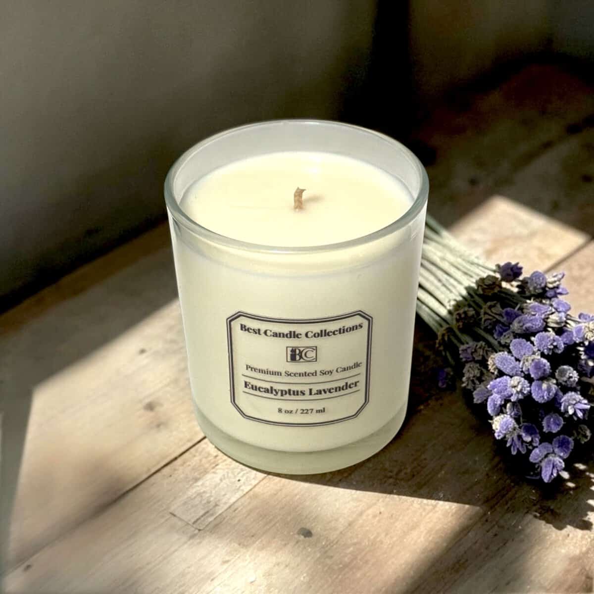 Handmade soy candle with fresh Eucalyptus Lavender scent in a cozy bedroom setting.