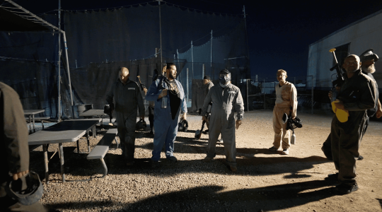 Suspenseful night scene with men in work uniforms holding tools and gear, set outdoors at night, emphasizing camaraderie and rugged teamwork for the Big Balls Brotherhood.