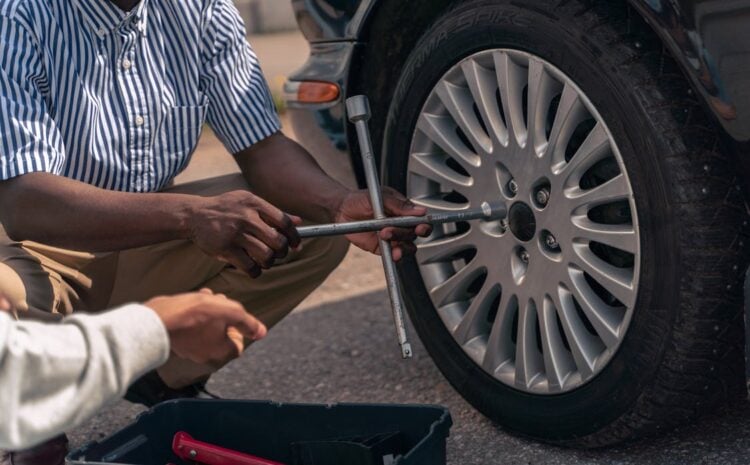 Auto mechanic adjusting car wheel at Blas Auto Service.