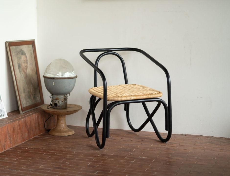 Silla de ratán negro Frank Black junto a una lámpara