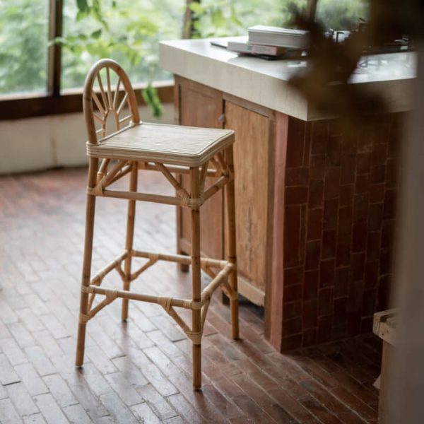 Taburete alto de ratán Nara Natural junto a una barra de cocina