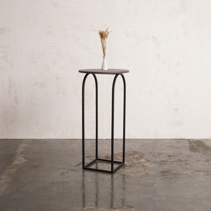 Mesa alta U de metal negro con flor seca, vista de tres cuartos
