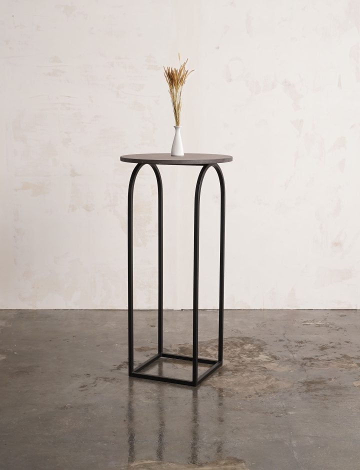 Mesa alta U de metal negro con flor seca, vista de tres cuartos