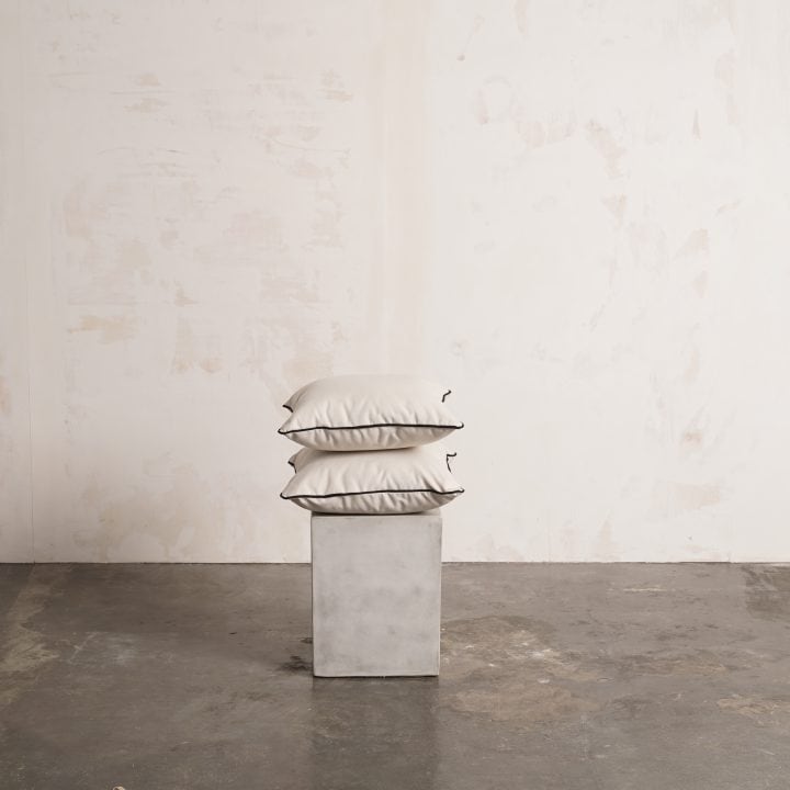 Cojines Fara blancos apilados sobre un pedestal de hormigón