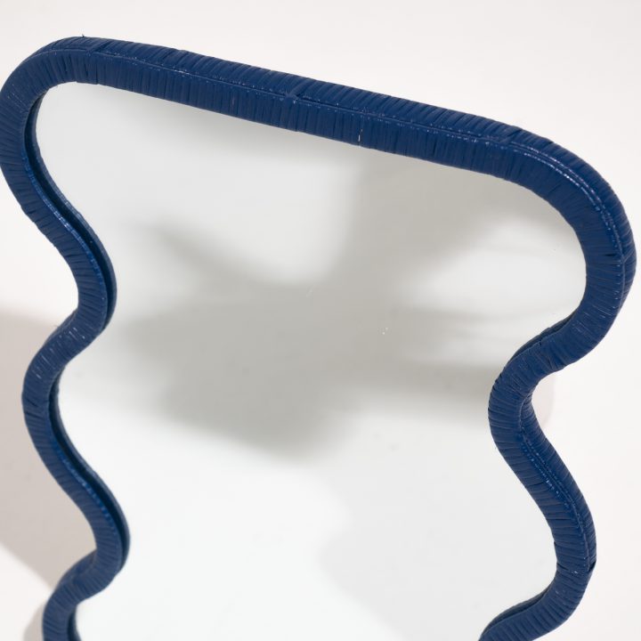 Detalle de la forma ondulada del espejo de ratán azul Lima