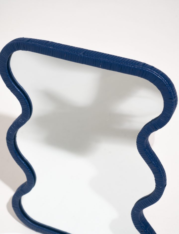 Detalle de la forma ondulada del espejo de ratán azul Lima