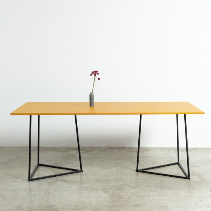 Mesa Kolor con caballetes negros y tablero de color para comidas de equipo y eventos de marca