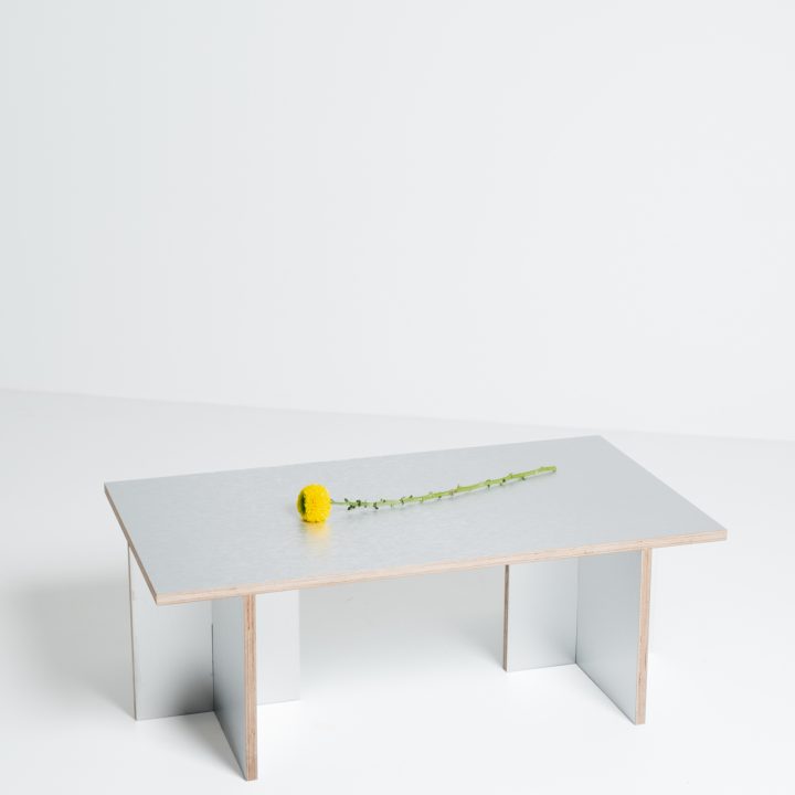 Mesa Cross con objeto decorativo, vista de tres cuartos