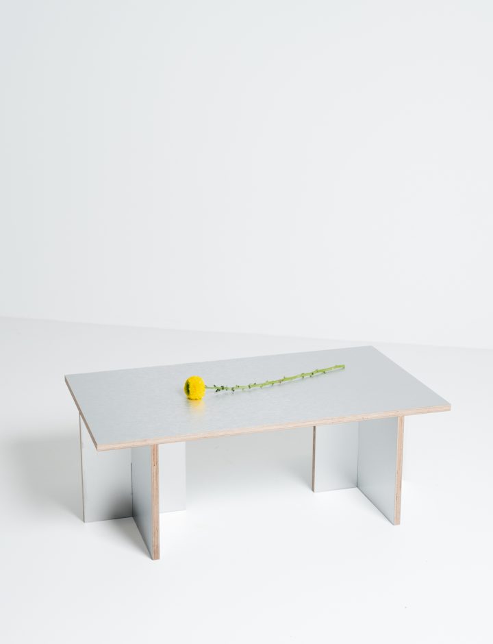 Mesa Cross con objeto decorativo, vista de tres cuartos