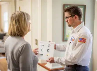 A Bonfe technician in uniform presents a sheet with helpful icons to a customer inside her home, taking time to explain the Membership Plan options and review the Terms & Conditions.