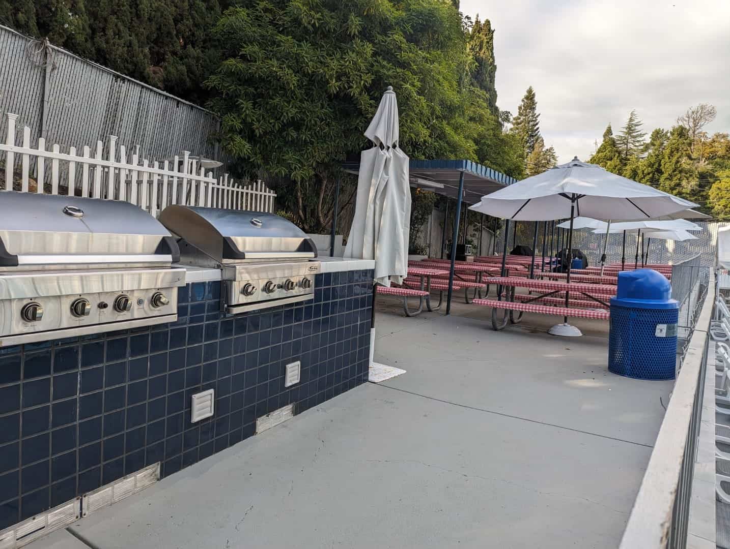 Grill stations and outdoor picnic tables at Bay-O-Vista Swim & Tennis Club, ideal for community events and gatherings.