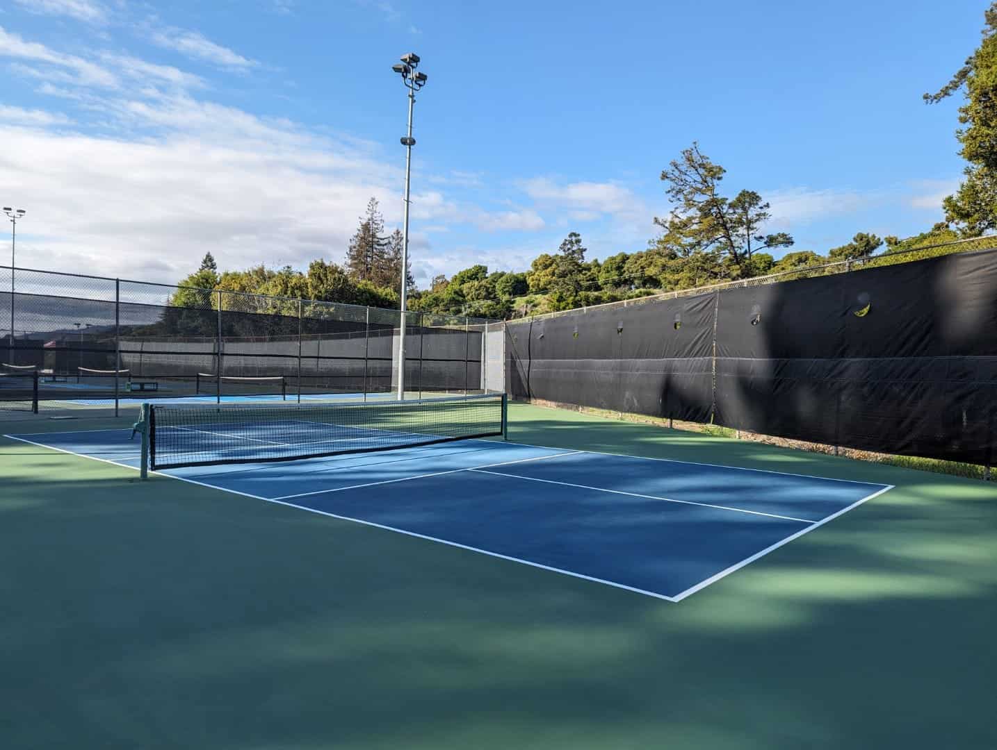 Tennis courts at Bay-O-Vista Swim & Tennis Club with well-maintained playing surface and surrounding privacy fencing. Ideal for tennis enthusiasts and club members to enjoy the sport.
