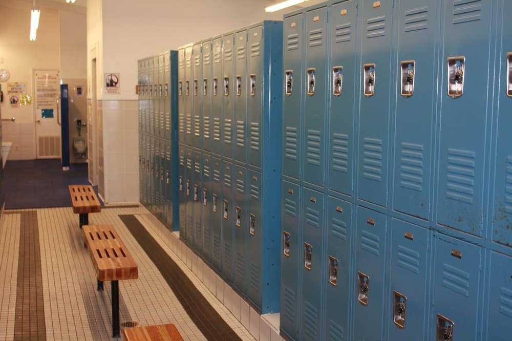 Row of blue metal lockers in a swim and tennis club locker room.
