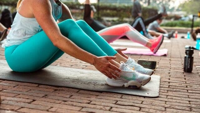 Comfortable women stretching before outdoor fitness class at Bay-O-Vista Swim & Tennis Club, promoting health, wellness, and active lifestyle.