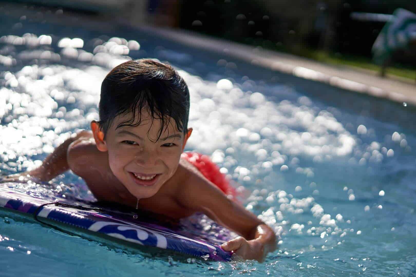 Kids swimming and having fun at Bay-O-Vista Swim & Tennis Club, a premier outdoor pool and tennis facility for family recreation and relaxation.