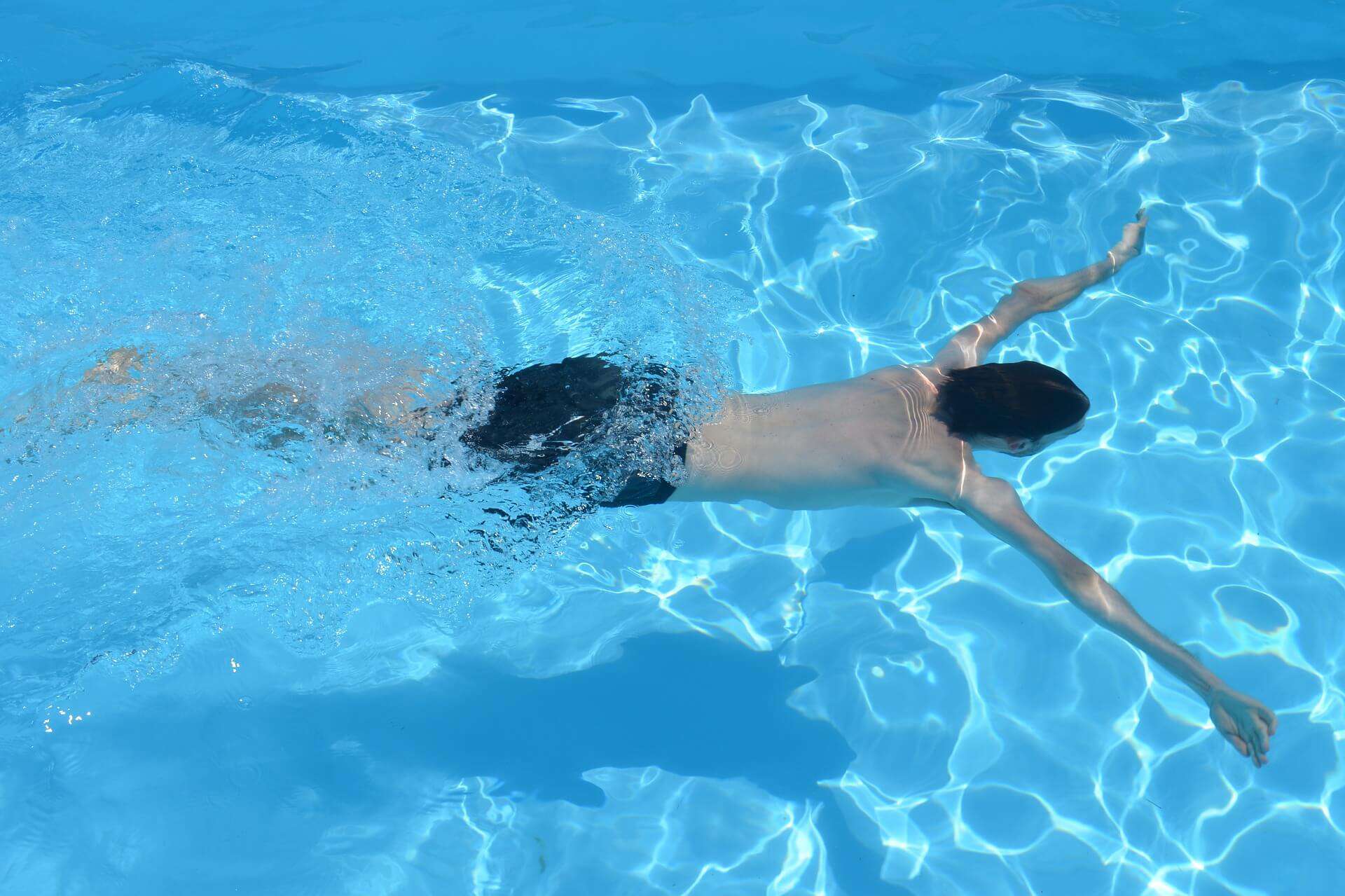 Boy swimming in outdoor pool at Bay-O-Vista Swim & Tennis Club, enjoying summer swimming and aquatic recreation.