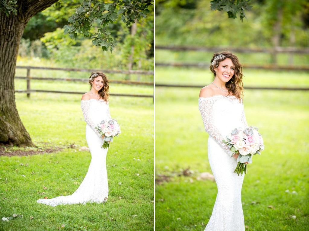 Mayowood barn Bride A Rochester bride in a white dress standing in front of a tree.