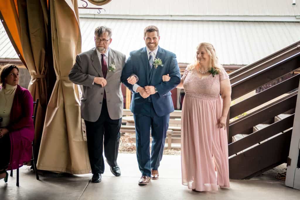 A bride and groom walking down the aisle at a train station.