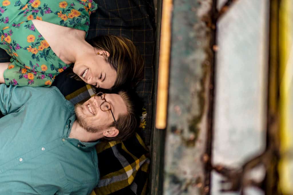 A couple laying on a bed in a car.