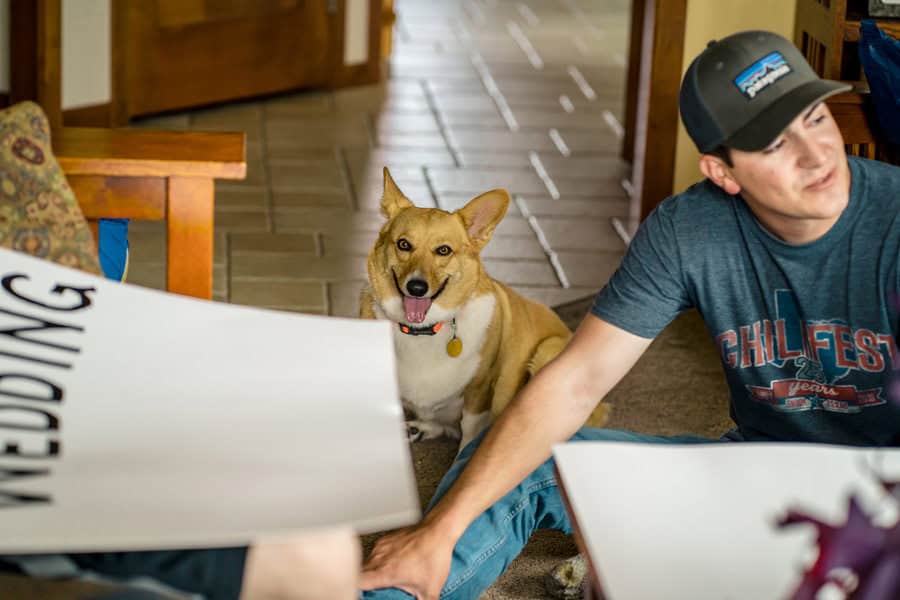 A man sits on the floor with a dog next to him.