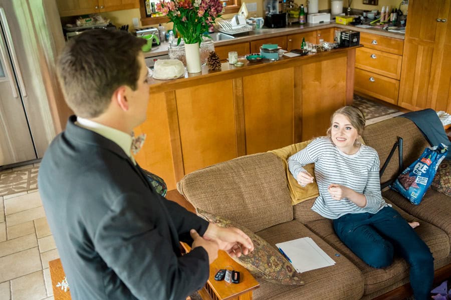 A man and woman sitting on a couch in a living room.