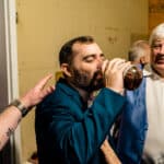 A man is drinking a beer in a love-filled room.