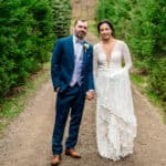 A Love-Filled Backyard Trempleau Wedding with Courtney and James standing on a dirt road in the woods.
