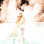 An emotional backyard wedding in La Crosse, featuring a bride and groom standing in a pool with smoke.