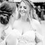 A bride and her bridesmaids dance at an outdoor wedding.