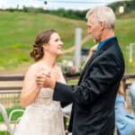 A bride and groom sharing their first dance at a mountain wedding.