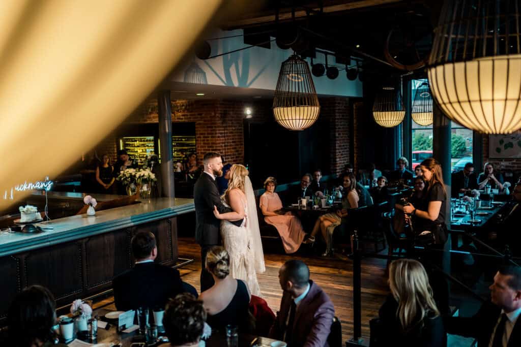 A bride and groom sharing their first dance in a restaurant.