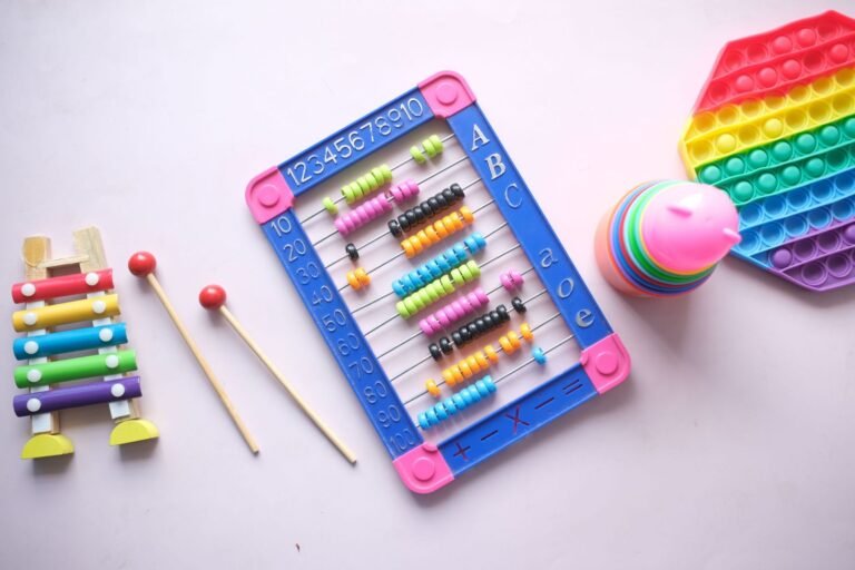 Sensory gifts for autistic kids: a rainbow pop-it fidget, wooden xylophone, bead abacus and stacking cups