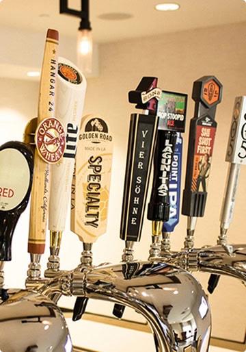 Draft beer taps at The Burger Place Anaheim, showcasing a variety of local and popular beer brands.