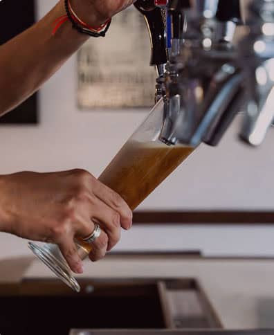 Beer being poured from a tap into a glass at The Burger Place Anaheim..