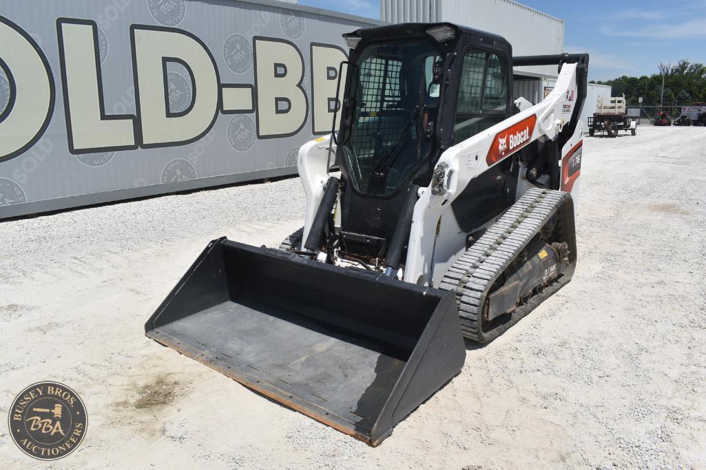 Mini skid steer loader with rubber tracks and front bucket attachment at Bussey Bros Auctioneers.