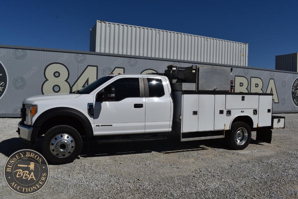White utility service truck with storage compartments at Bussey Bros Auctioneers.