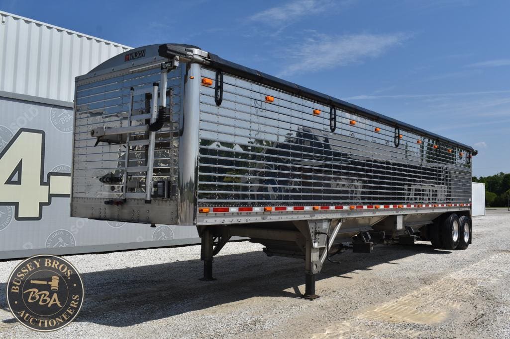 Livestock transport trailer with polished aluminum exterior and multiple ventilation windows.