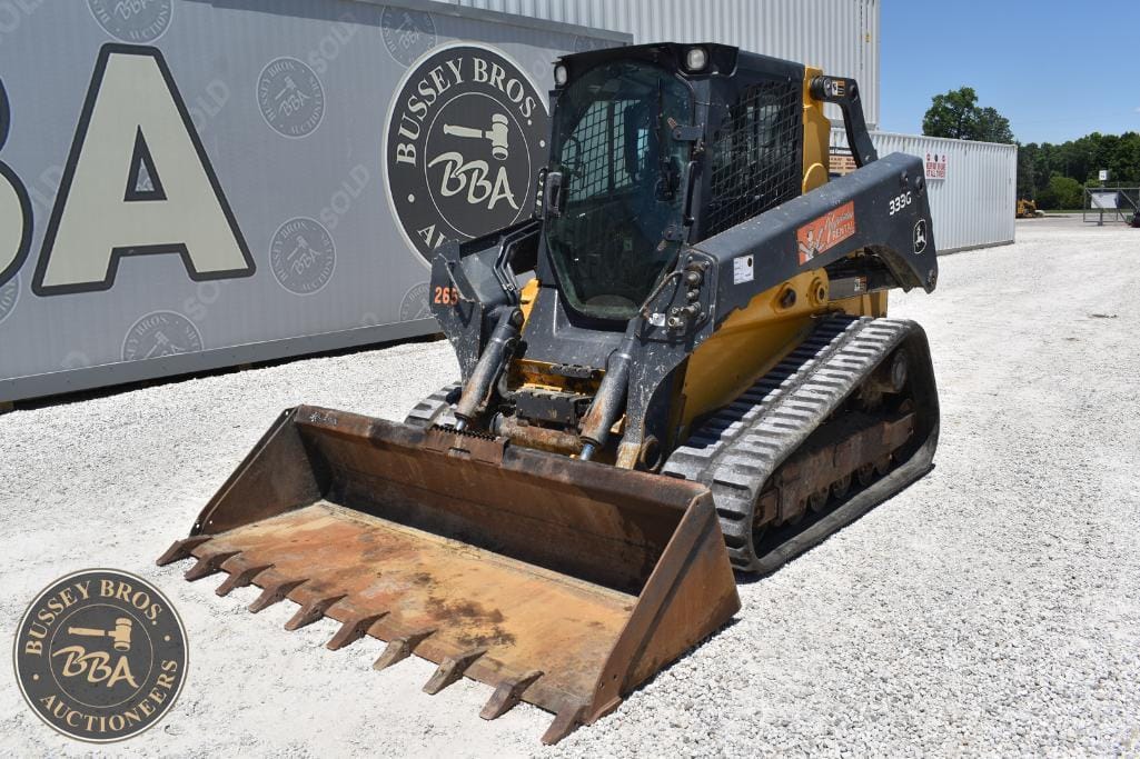 Skid steer loader with a rusted bucket parked outdoors at Bussey Bros Auctioneers.