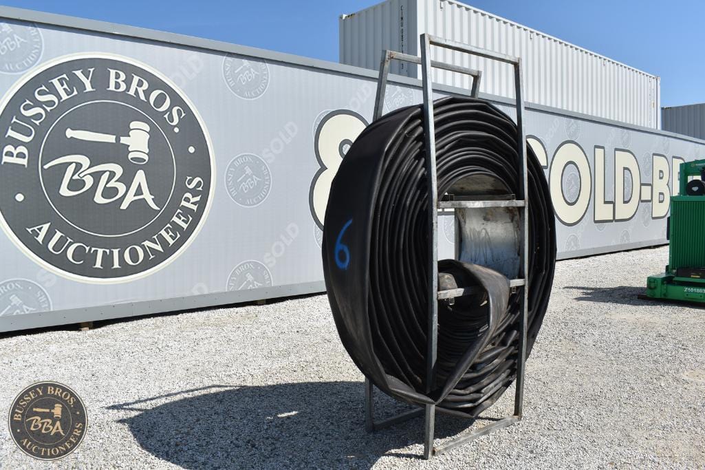Large black industrial hose reel outside Bussey Bros Auctioneers facility.